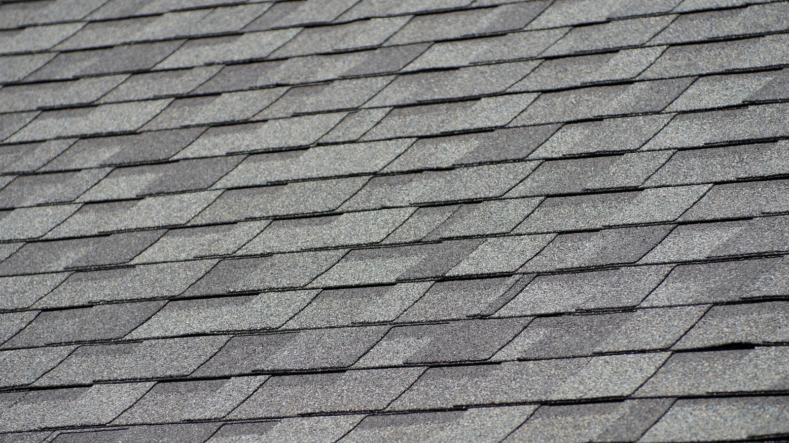 Overhead view of gray architectural asphalt shingles in overlapping rows